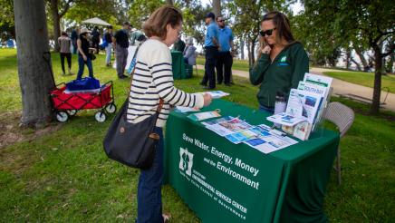 Staffer speaking with attendee at the South Bay Environmental Services Center booth