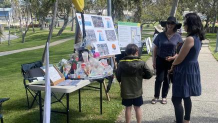 Mother and child speaking to booth staffer and observing displays