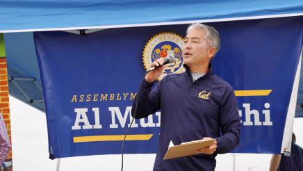 Assemblymember Muratsuchi speaks through a microphone
