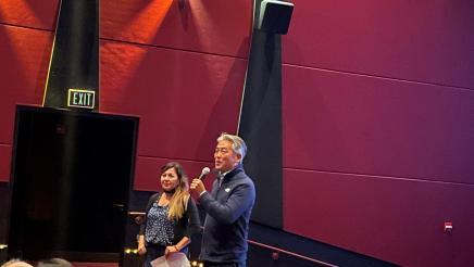 Asm. Muratsuchi standing and holding microphone, speaking