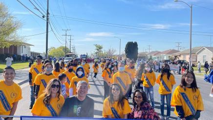 Asm. Muratsuchi holding banner with Denker Elem. School parade participants