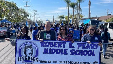 Asm. Muratsuchi holding banner with Peary Middle School parade participants