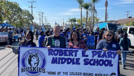 Asm. Muratsuchi holding banner with Peary Middle School parade participants