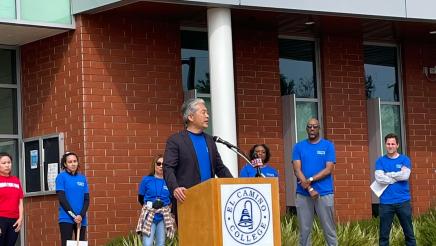 Asm. Muratsuchi at podium in front of building