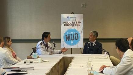 Asm. Muratsuchi seated at end of long table, speaking with physician