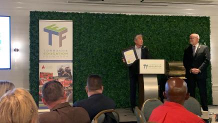 Asm. Muratsuchi on stage, presenting an award to the foundation