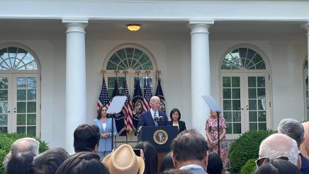 President Biden at podium, speaking to attendees