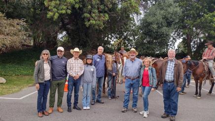 Asm. Muratsuchi with ride participants, horses in background