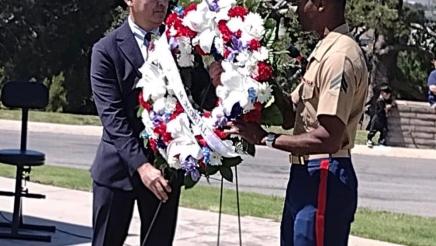 Asm. Muratsuchi assisting military member in placing standing wreath