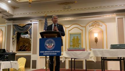 Asm. Muratsuchi on stage, speaking at podium
