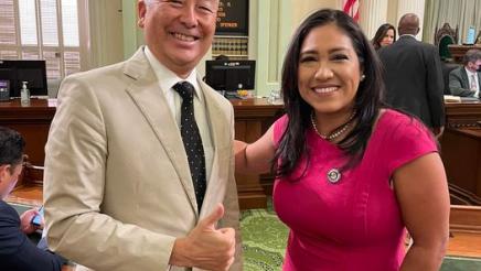 Assemblymember Muratsuchi stands next to Assemblywoman Suzette Valladares on the State Assembly floor in front of the vote totals showing passage of AB2432.