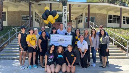 Asm. Muratsuchi, with district staff and students, holding check