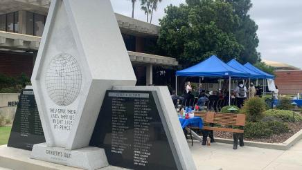 Close-up of war memorial, with event attendees in background