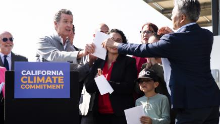 Assemblymember Al Muratsuchi exchanges paper with Governor Gavin Newsom