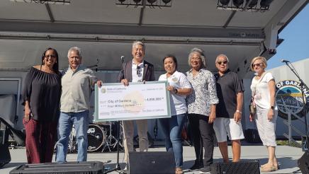 Group photo with Asm. Muratsuchi at center, holding large check