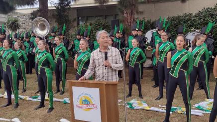 Asm. Muratsuchi at podium with parade performers in background