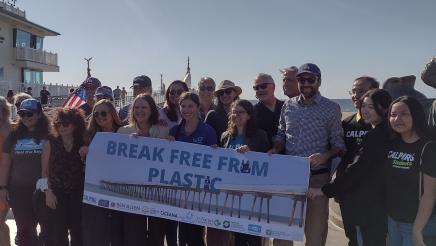 Group photo with large banner held up at middle