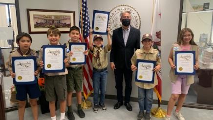 Group photo of Asm. Muratsuchi with scouts holding certificates
