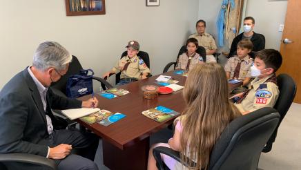 Asm. Muratsuchi sitting at table with scouts