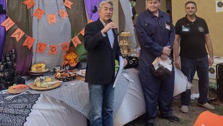 Asm. Muratsuchi with microphone, speaking, as George Casillas and staffer listen on