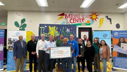 Group photo with large check held at center