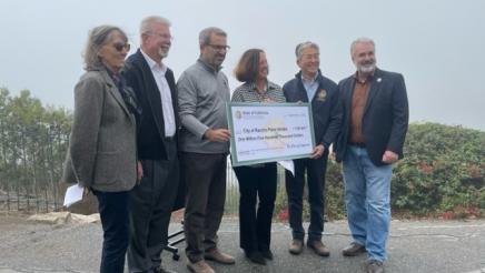 Group photo with large check held at center