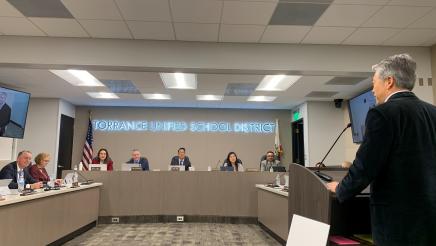 Asm. Muratsuchi at podium, speaking to seated baord members