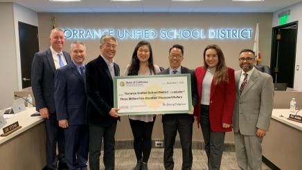 Group photo with large check held at center