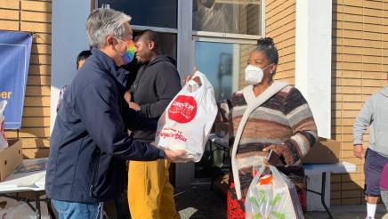 Asm. Muratsuchi handing food bag to constituent