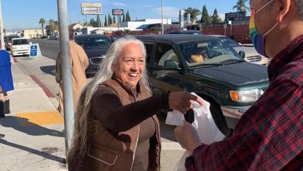 Asm. Muratsuchi distributing food bag to happy constituent