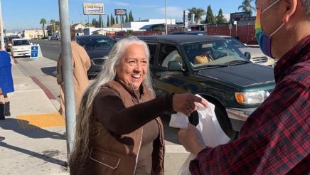 Asm. Muratsuchi distributing food bag to happy constituent