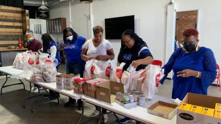 Volunteers packing bags on top of table