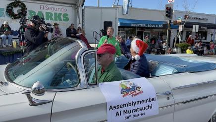 Asm. Muratsuchi in back of car, holding up ornament