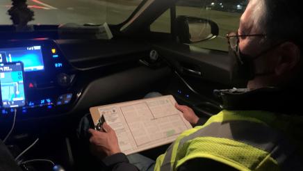Asm. Muratsuchi in car's passenger seat, viewing chart