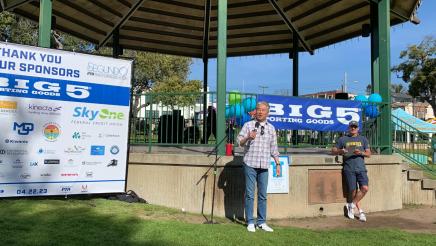 Asm. Muratsuchi holding microphone, speaking to run participants