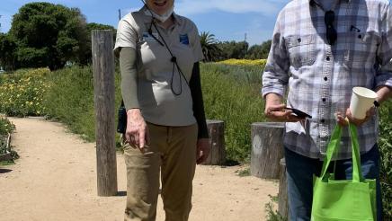 Guide pointing out flowers as Asm. Muratsuchi listens on