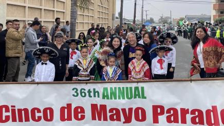 Asm. Muratsuchi with parade participants in costume, holding banner