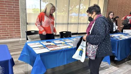 Staffer at table, helping constituent select informative materials