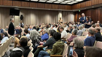 Attendee asking question as Asm. Muratsuchi and large audience listen on