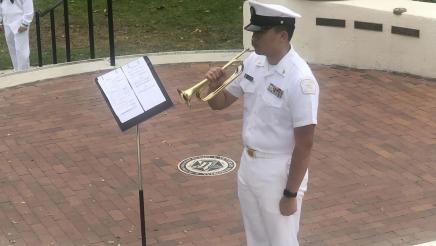 Service member standing, holding trumpet