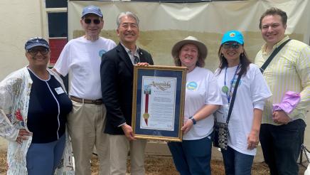 Asm. Muratsuchi presenting framed award to Open Doors Peninsula members