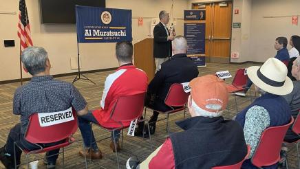 Asm. Muratsuchi at head of room, speaking to attendees