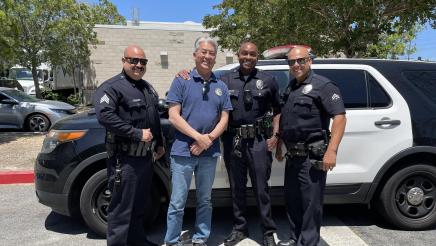 Asm. Muratsuchi standing with three police officers in front of squad car