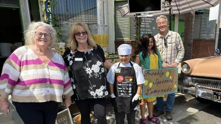 Asm. Muratsuchi in front of lemonade stand with students and adults