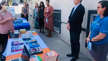 Asm. Muratsuchi and other tour participants listen on as informational booth staffer speaks