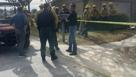 Asm. Muratsuchi speaking with first responder, with multiple first responders in background