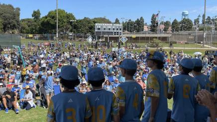 Team being honored by large gathering at baseball field