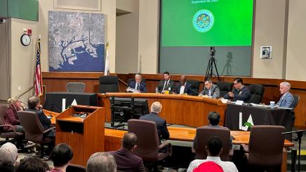Committee members listen on as Asm. Muratsuchi speaks into microphone