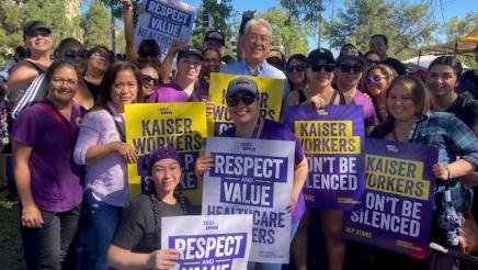 Asm. Muratsuchi with multiple striking healthcare workers holding signs