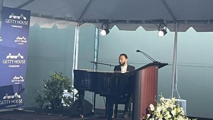 John Legend playing piano and singing